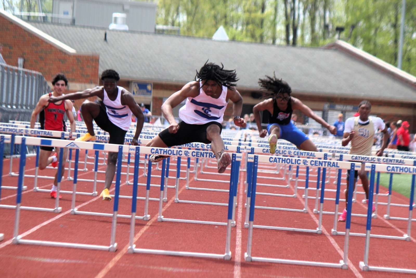 Novi Detroit Catholic Central senior Zacchaeus Brocks powers to first place in record time for the 110-meter high hurdles, propelling the Shamrocks to the Catholic High School League’s Bishop Division team title on their home track May 9.