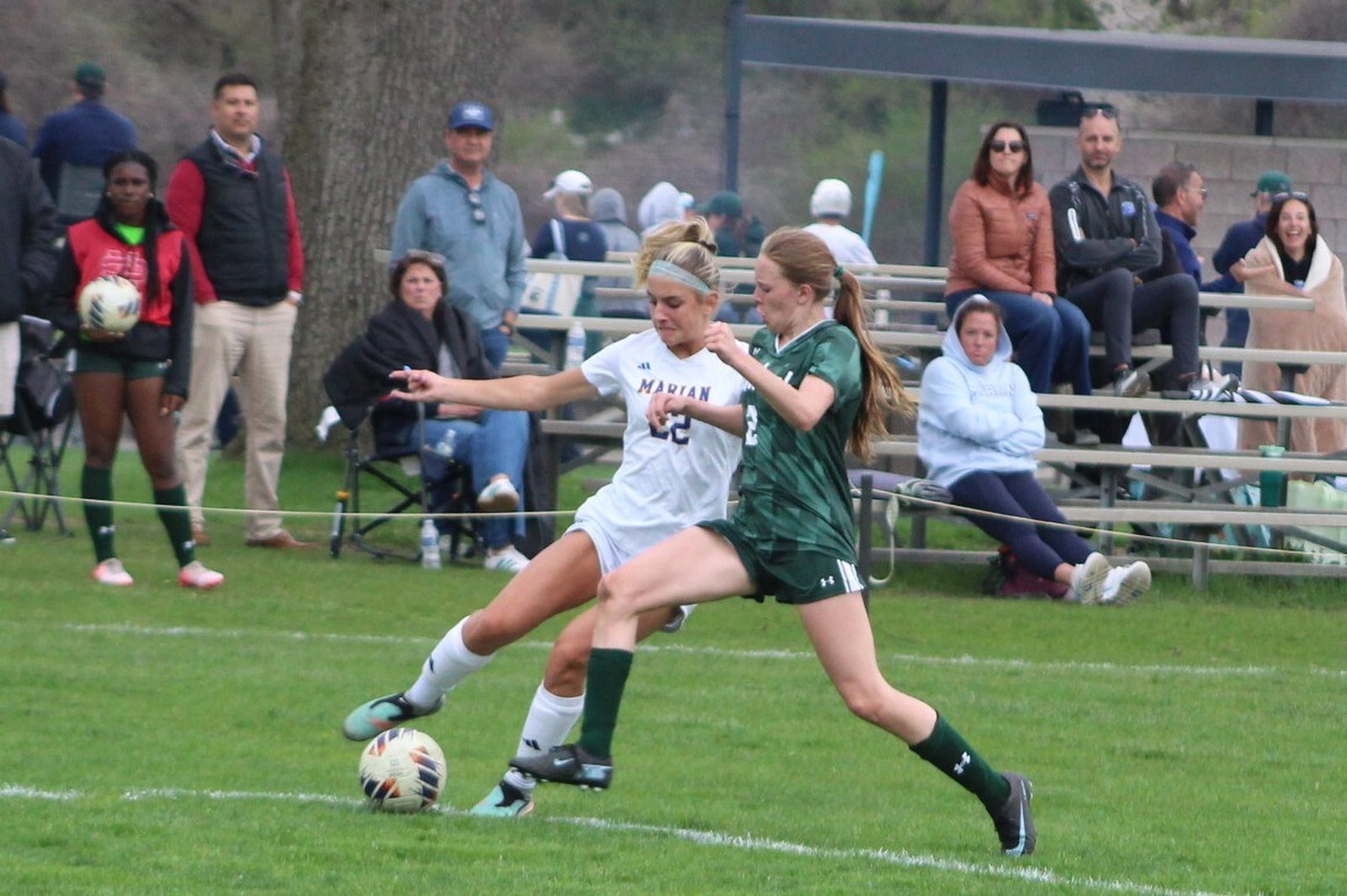 Marian’s Giselle Gniatczyk fights a defender for a 50/50 ball during the second half of the Mustangs’ 6-0 win on Cranbrook’s lower field April 21.