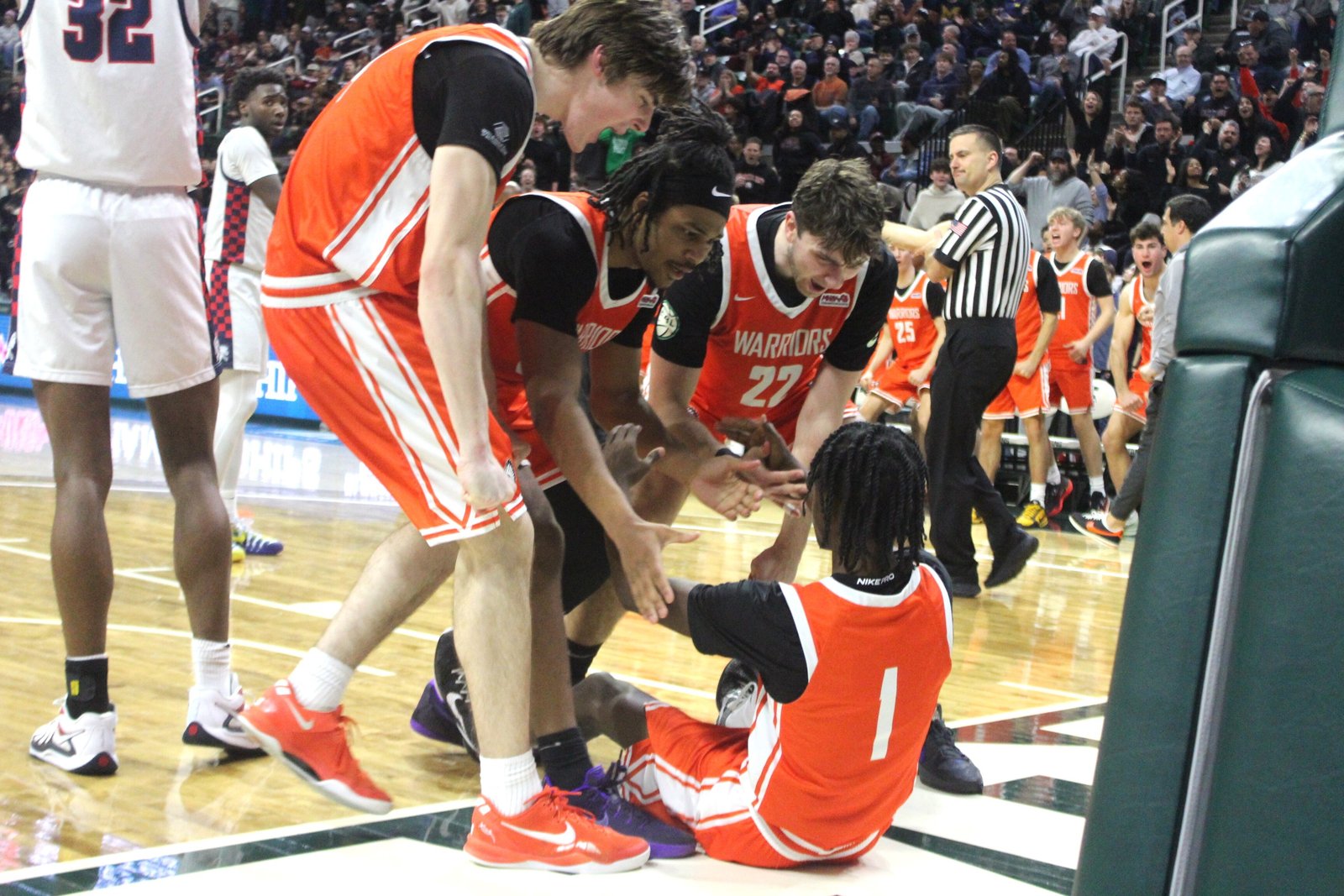 Ivan Stojanovski, Greg Grays and Trevor Smith help teammate Jordan McDaniel up after he was fouled making a lay-up in the final minute of Brother Rice’s 55-52 loss to East Lansing in the MHSAA Division 1 state semi-finals.
