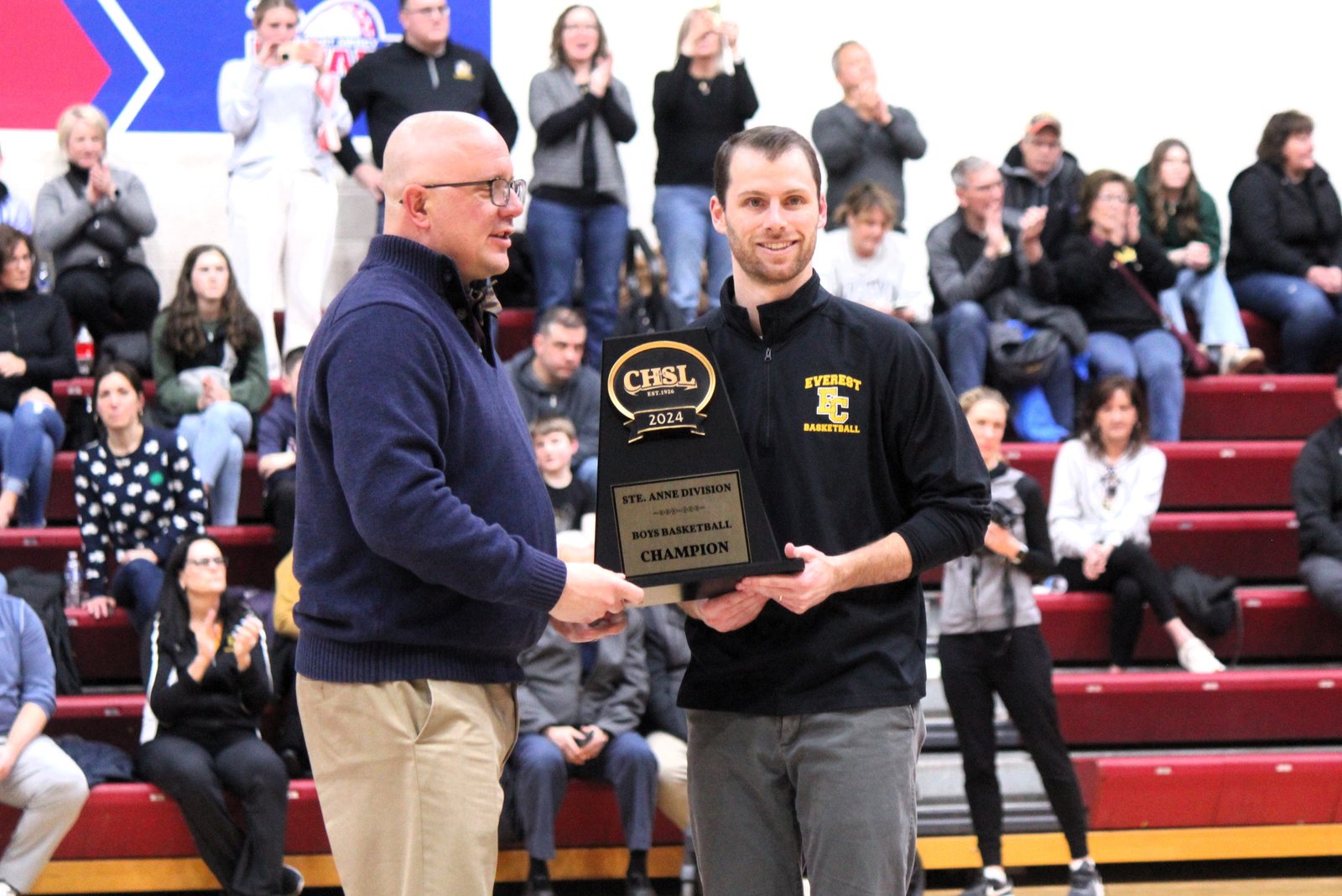 One of Evoy’s roles as CHSL associate director was to regulate and oversee awards for student-athletes. Here, he presents the Catholic League’s St. Anne Division championship trophy to Clarkston Everest Collegiate basketball coach Rich Cross in February 2024.