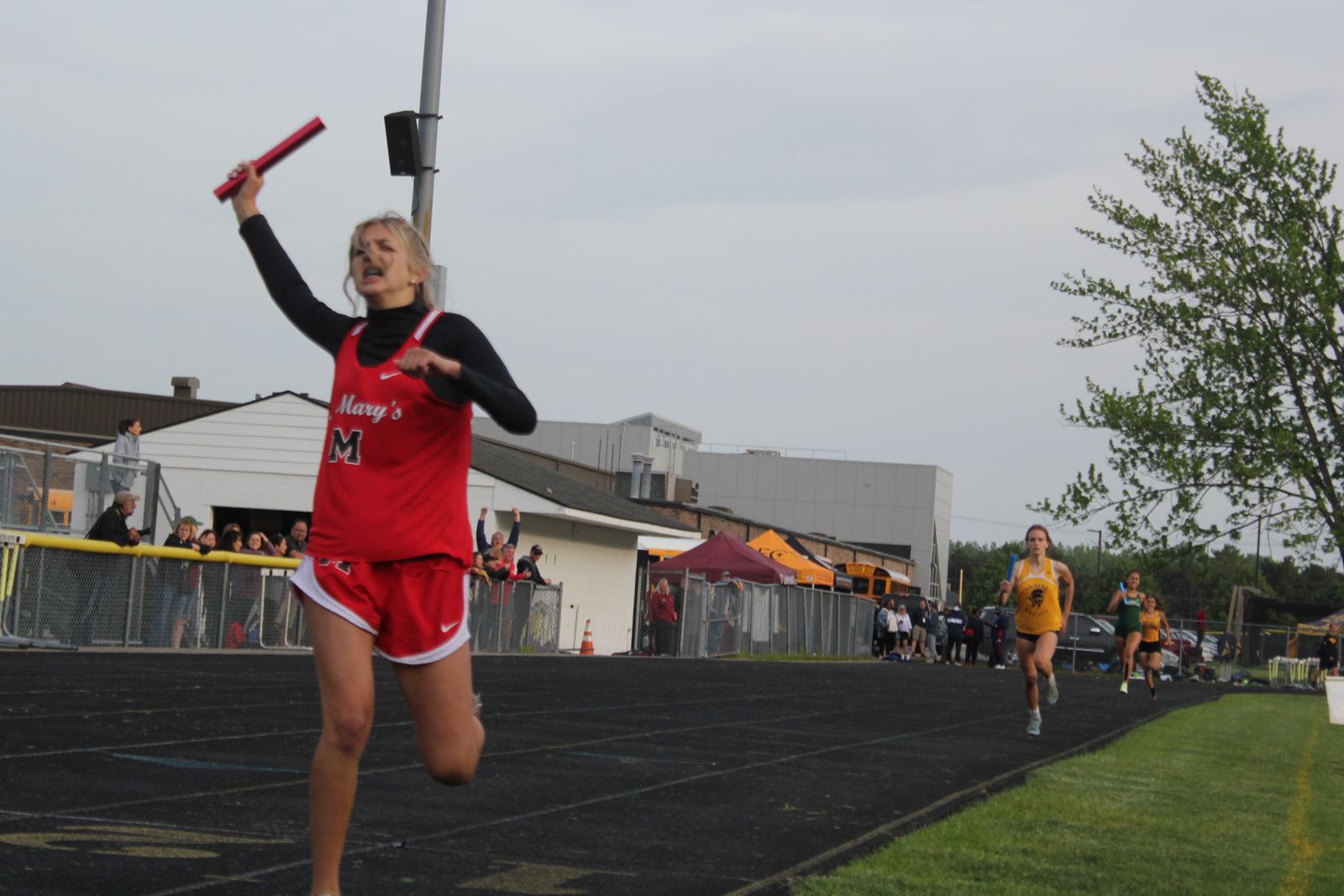 Holding her baton high in the air, Orchard Lake St. Mary’s Siena Machak crosses the finish line first, helping the Eaglets win the 4x400 meter relay.