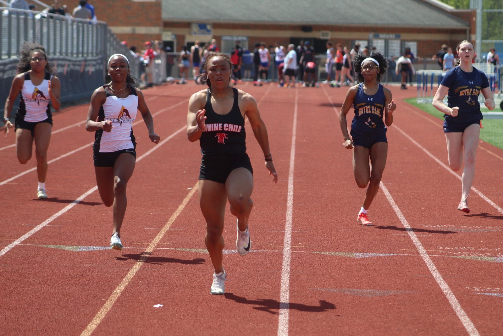 Dearborn Divine Child sophomore Aubrey Wilson leads the field as the 100-meter dash finish line approaches. She won four events in the Bishop Division meet, setting Catholic League records in the 200 dash and 4x400 relay.