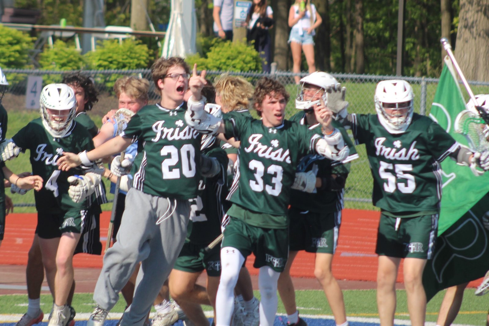 Happy Ann Arbor Fr. Gabriel Richard teammates celebrate with Cullen Gaves (33) after he scored the game-winning goal in the second overtime of the Cardinal Division championship to defeat Dearborn Divine Child, 11-10.