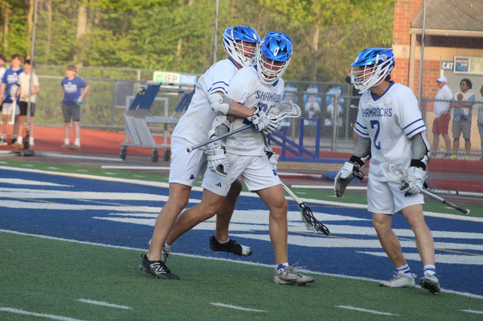 Connor Lukas (left) and Ben Papke (right) rush to congratulate Lachlan Moffatt on his game-winner in Detroit Catholic Central’s 12-11 overtime victory in the Catholic High School League’s Bishop Division lacrosse final.