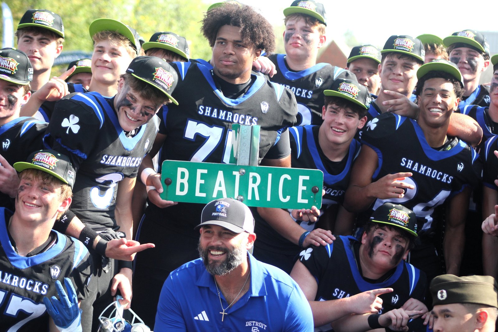 Penn State University commit Benny Eziuka holds up the team’s “Beatrice” (Beat Rice) street sign as his Detroit Catholic Central teammates and coaches relish their 41-8 victory.