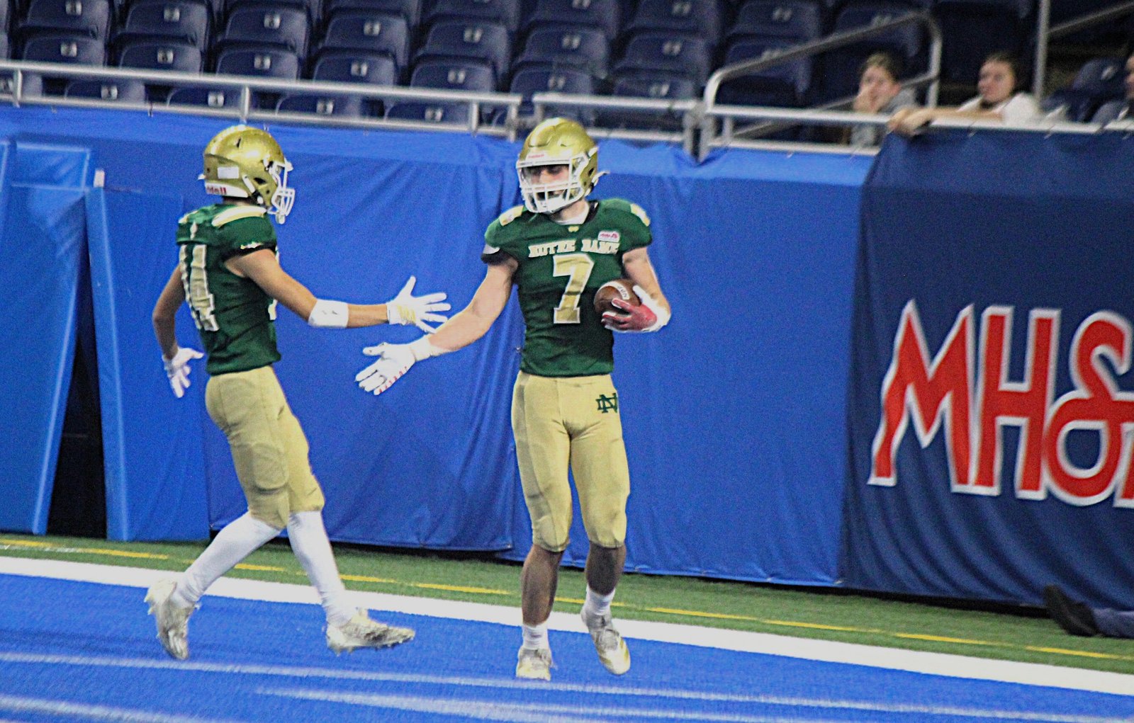 Notre Dame Prep’s Anthony Tartaglia congratulates Brody Sink after his 60-yard touchdown pass reception in the fourth quarter of the Fighting Irish loss to Grand Rapids West Catholic.