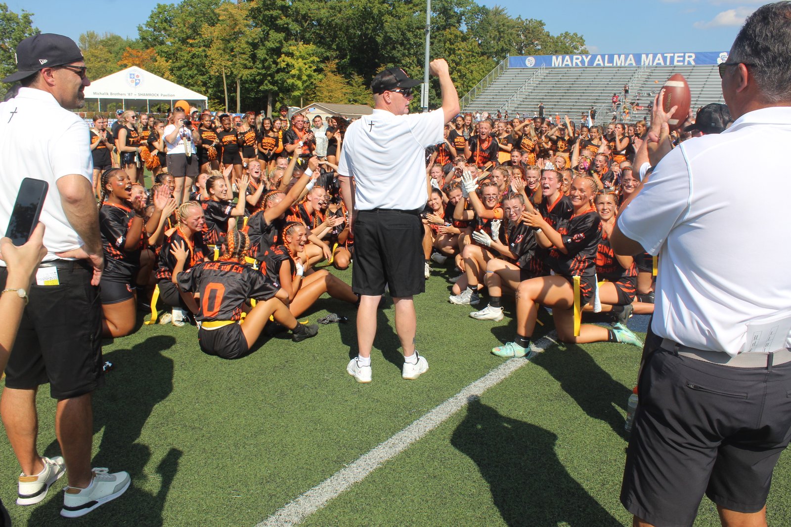 In a post-game speech, head coach Scott Smith congratulates his Warren Regina team, surrounded by the student section and alumnae. The Class of 2026 adopted “Tigers” as the squad’s identity, with uniforms and hairstyles to match.