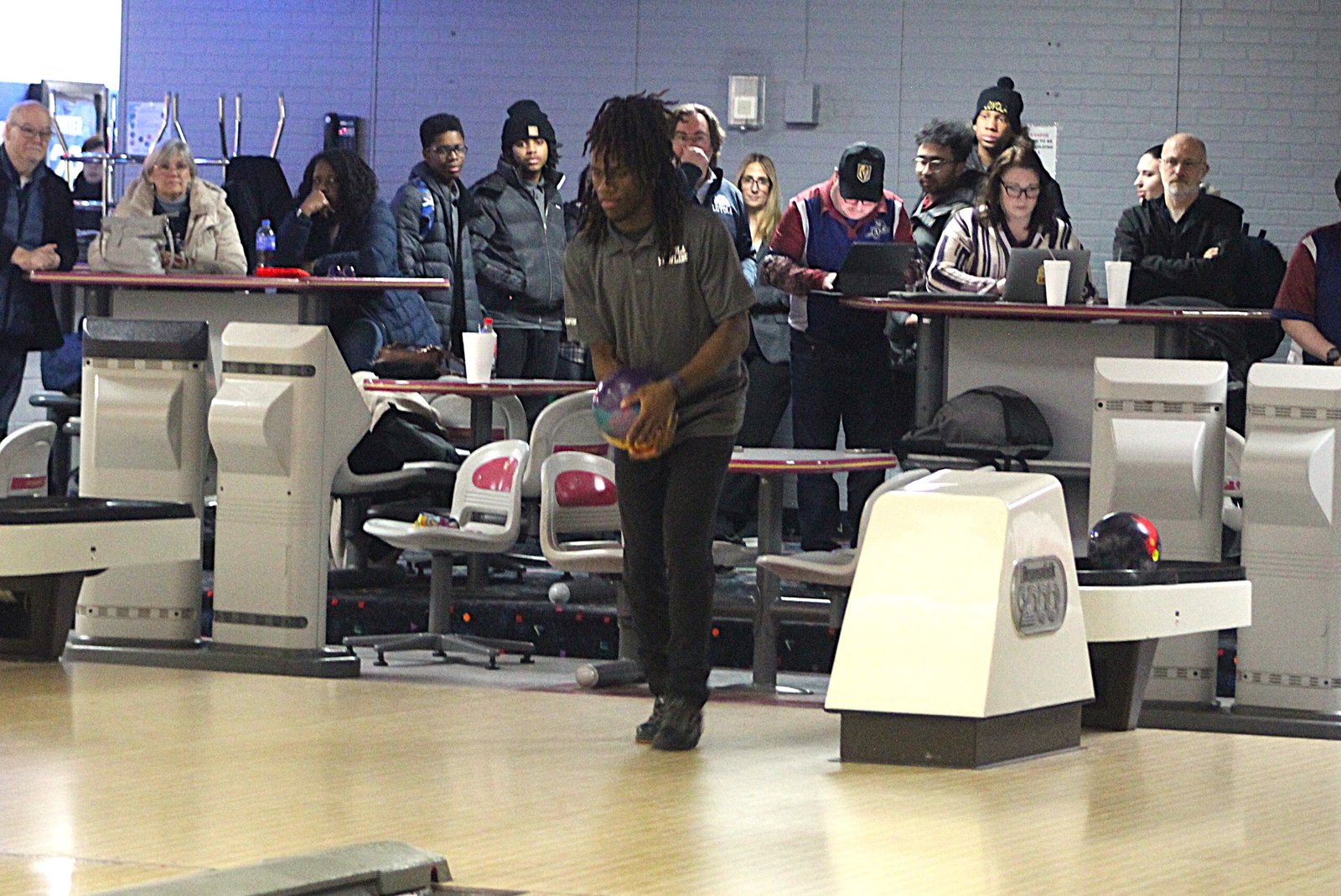 Onlookers crowd around to watch Loyola senior Cody Champion finish his second game during a Catholic League dual match.